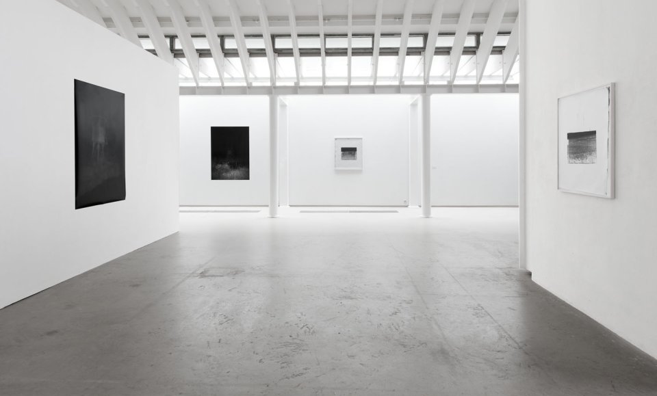 Ein Einblick in die Galerieräume, strahlend weiße Wände mit schwarz-weißen Bildern.